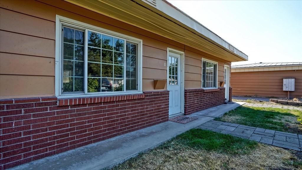 A house with a red brick wall and a white door.