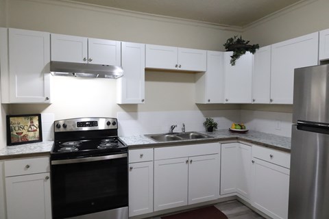 A kitchen with white cabinets and a black stove top oven.