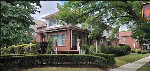 a brick house with a sidewalk in front of it