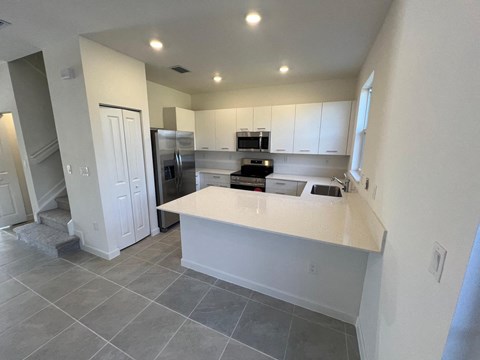 a kitchen with white cabinets and a counter top