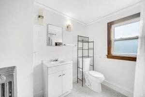 a white bathroom with a toilet and a sink