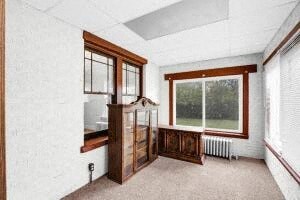 a large living room with a large window and a wooden cabinet