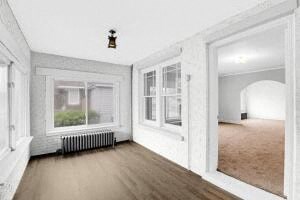 a living room with a wooden floor and a large window