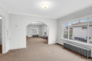 an empty living room with a large window and a radiator
