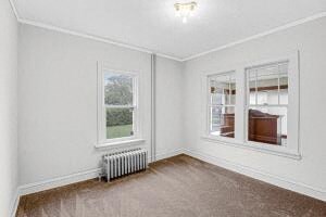 an empty room with a radiator and two windows
