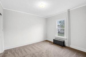 an empty room with a radiator and a window
