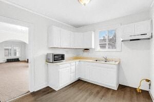 a kitchen with white cabinets and a sink and a microwave