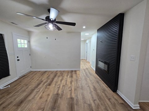 a living room with a wood floor and a ceiling fan