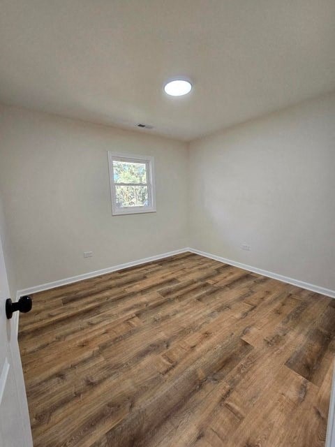 an empty room with wooden floors and a window