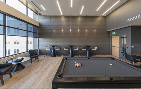 a game room with a pool table and chairs
