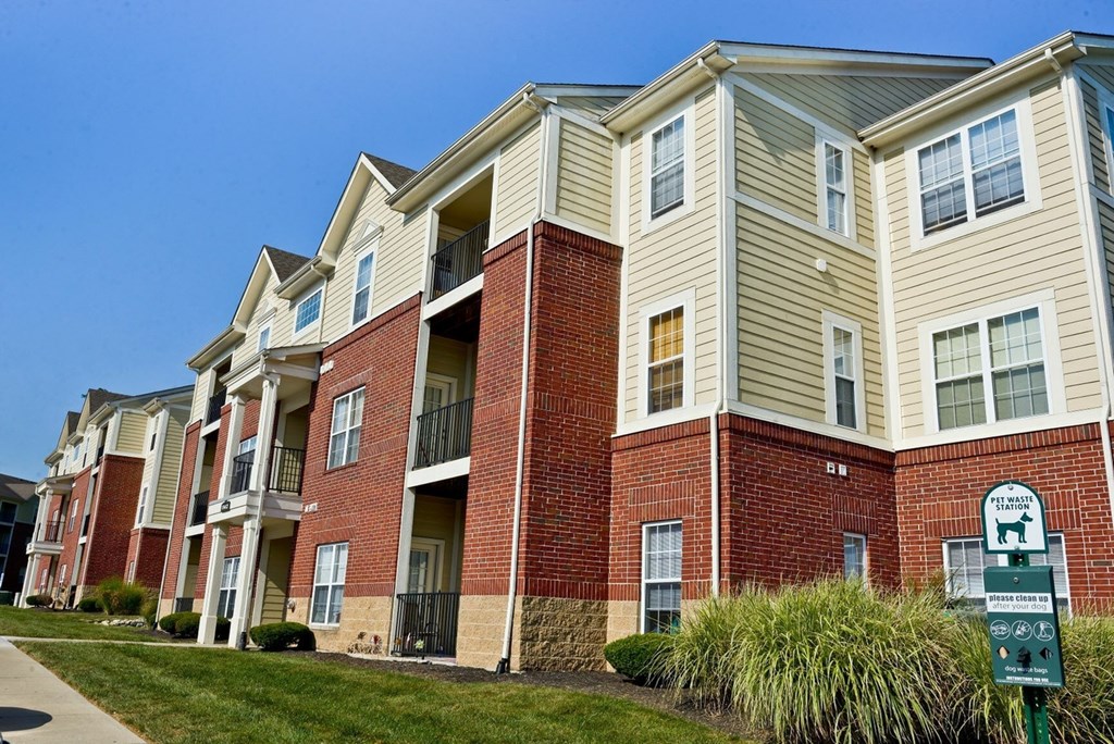 an apartment building with a sign in front of it