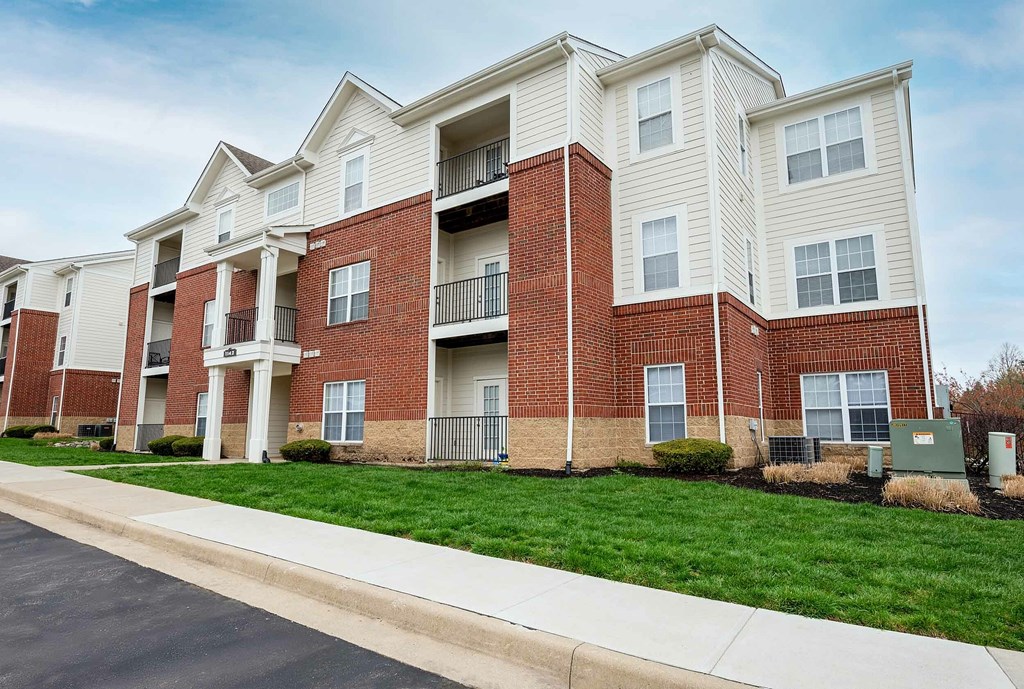 A large apartment building with multiple balconies and doors.