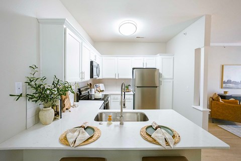 A kitchen with white cabinets and a wooden floor.