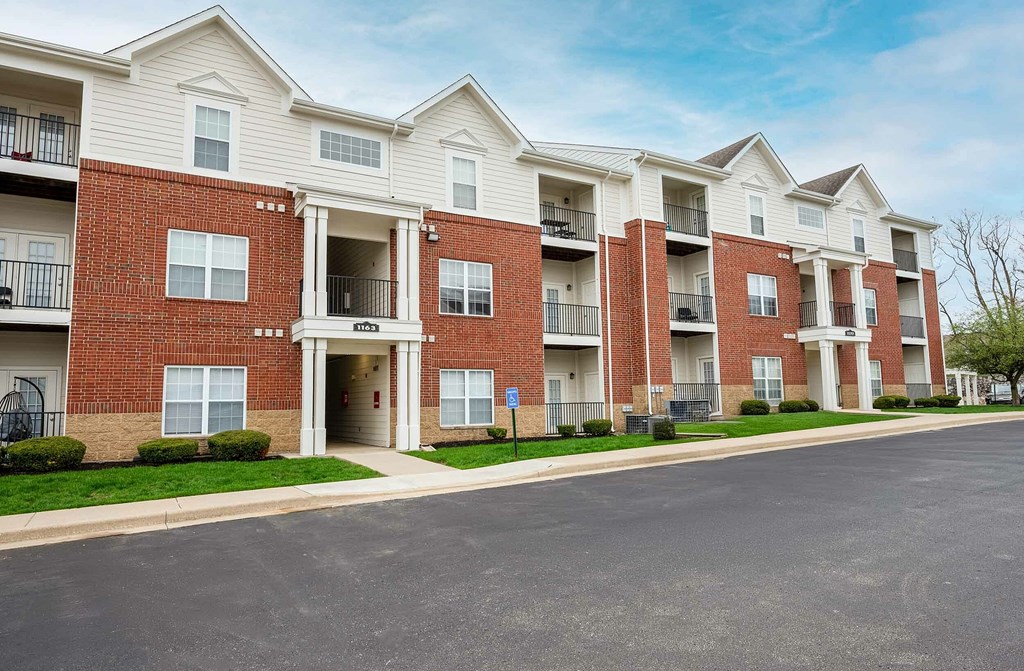 A row of red brick apartment buildings with white trim and balconies.