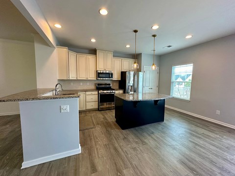 a kitchen with white cabinets and a black counter top