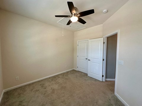 a bedroom with carpet and a ceiling fan