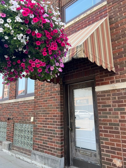 A building with a striped awning and a door with a window above it.