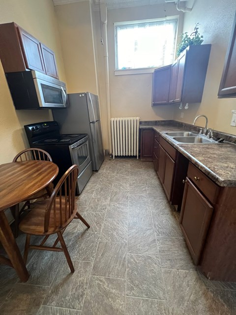 A kitchen with a table and chairs.