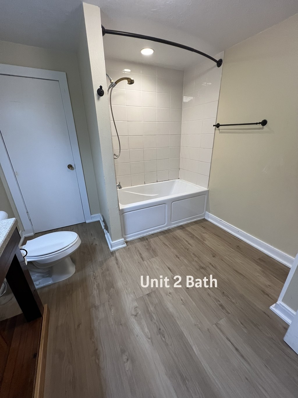 A bathroom with a toilet, a bathtub, and a shower.