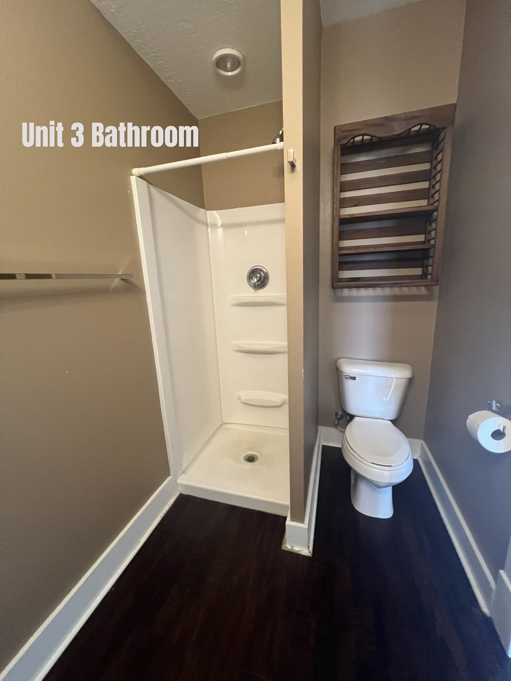 A bathroom with a toilet and a shower stall.