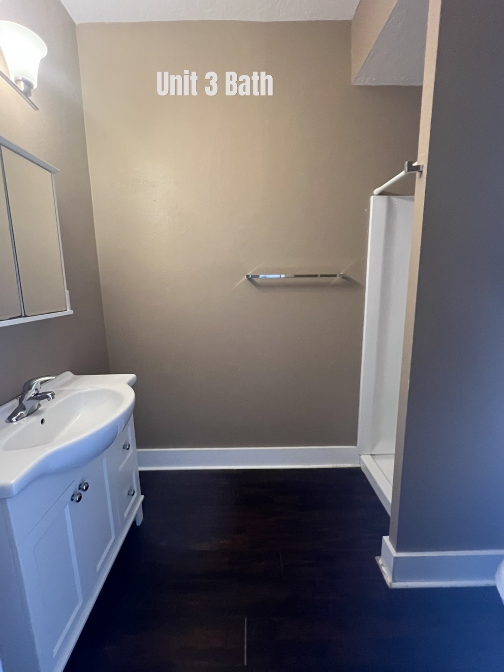 A bathroom with a tub, sink and toiletries.