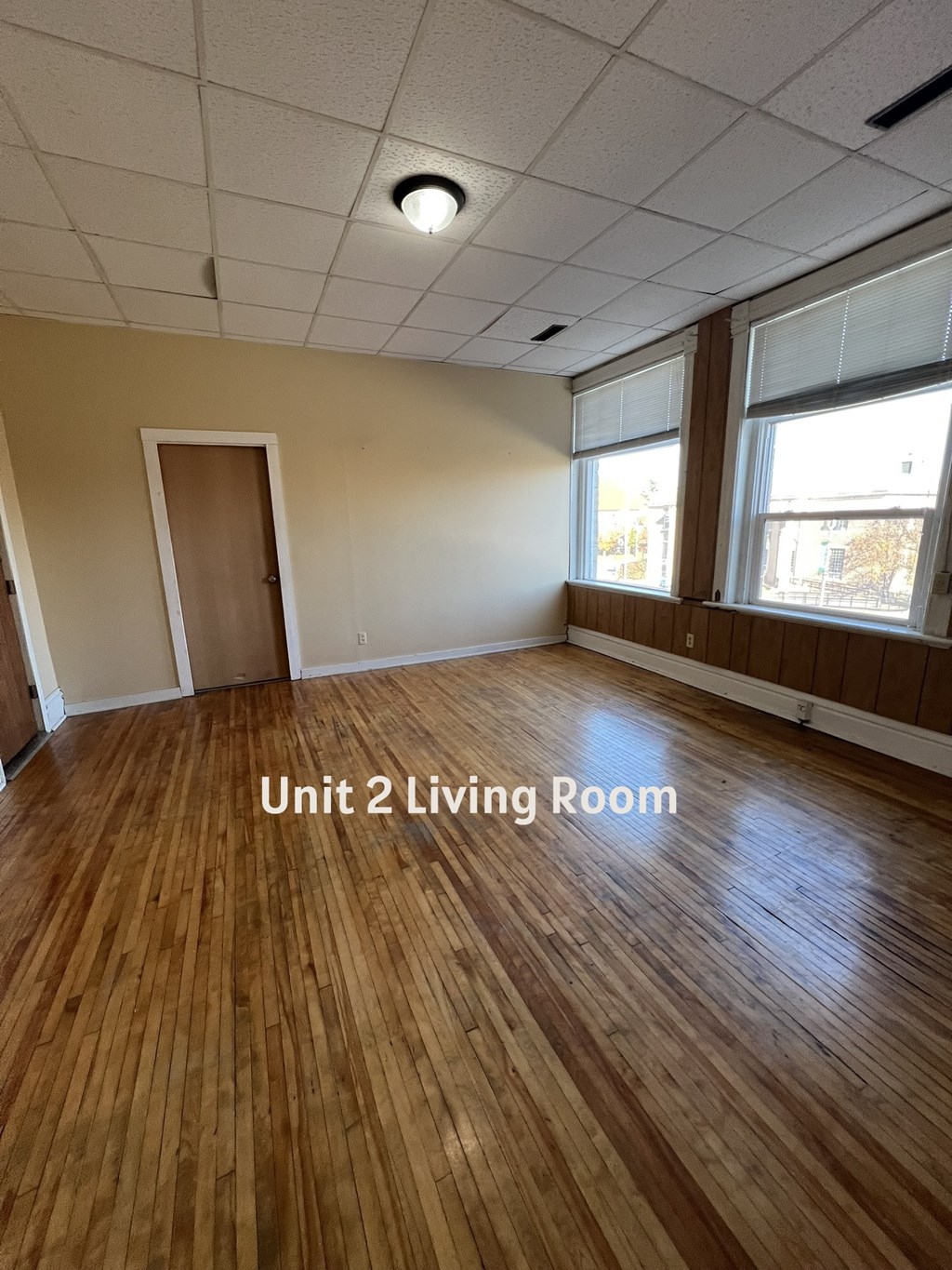 A living room with wooden floors and a door.