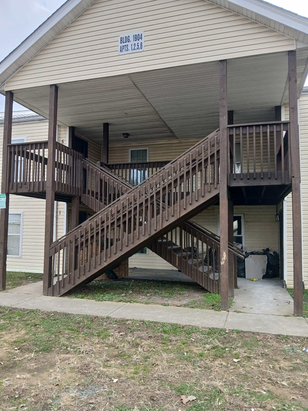 A wooden deck with a staircase leading to a house.
