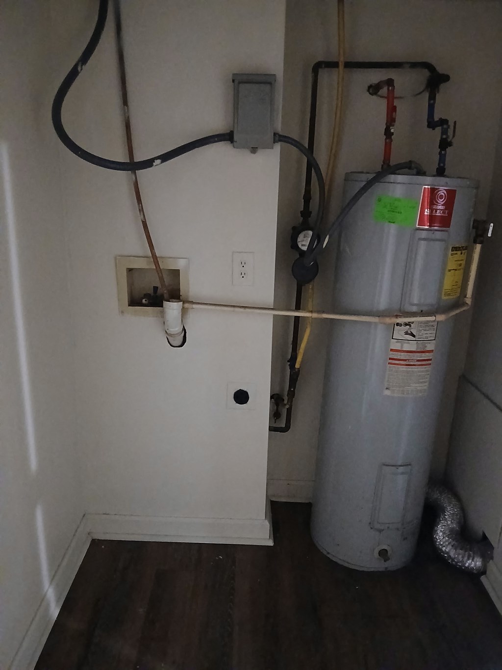 A grey water heater with a yellow tape on it.