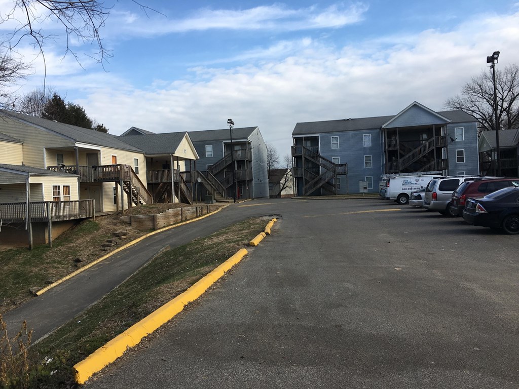 A parking lot with a yellow line and cars parked in the background.