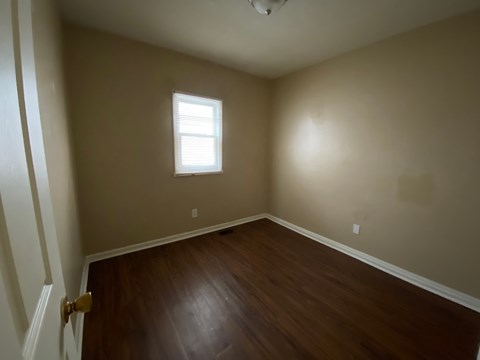 A room with a wooden floor and a window.