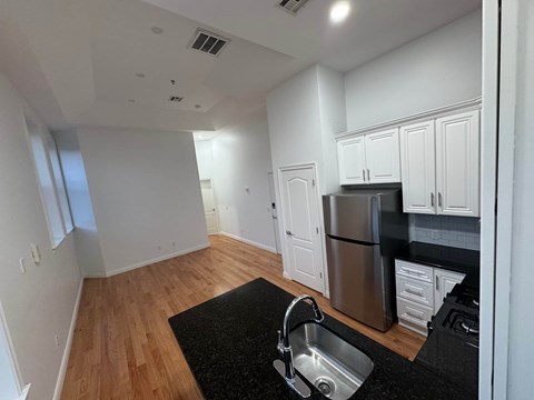 A kitchen with a sink and a refrigerator.