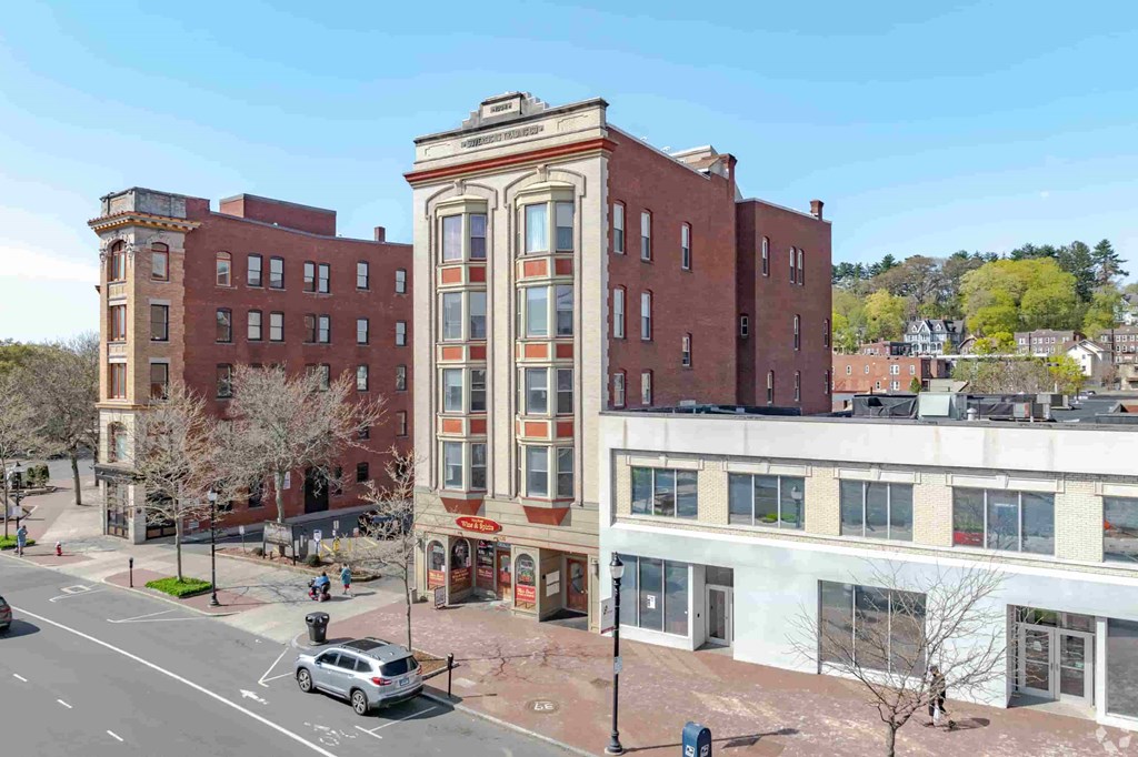 A street view of a city with a large building in the middle.
