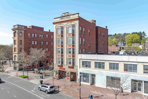 A street view of a city with a large building in the middle.