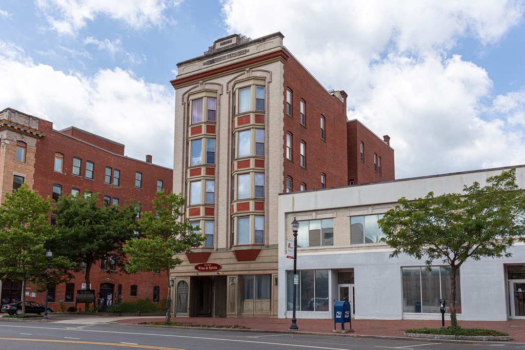 A red brick building with a white trimmed window.