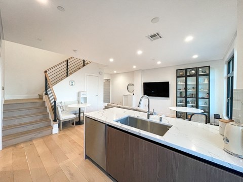 a kitchen with a sink and a counter top and a staircase
