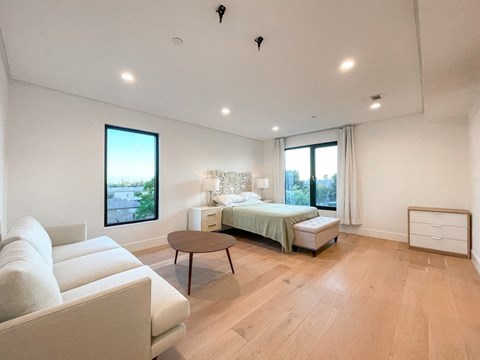 a bedroom with a bed and a couch and a table