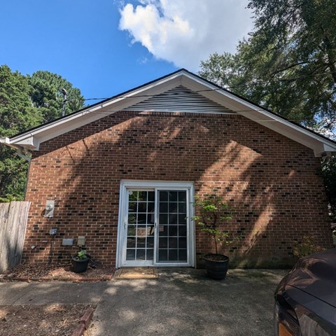 a brick house with a window and a driveway