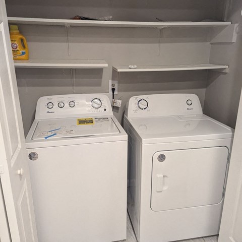 a white washer and dryer in a closet