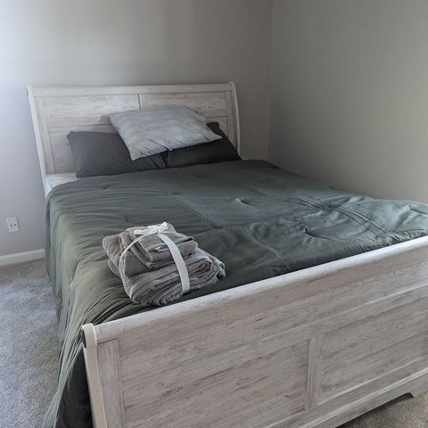 a bedroom with a bed and a blanket and pillows