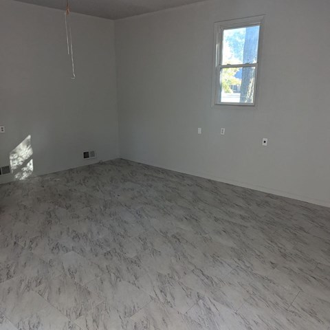 an empty room with white marble floors and a window