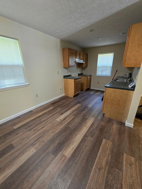 an empty kitchen with wooden floors and wooden cabinets