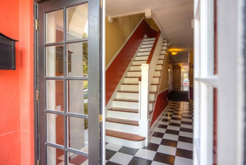 the stairs to the second floor of a building with a checkered floor