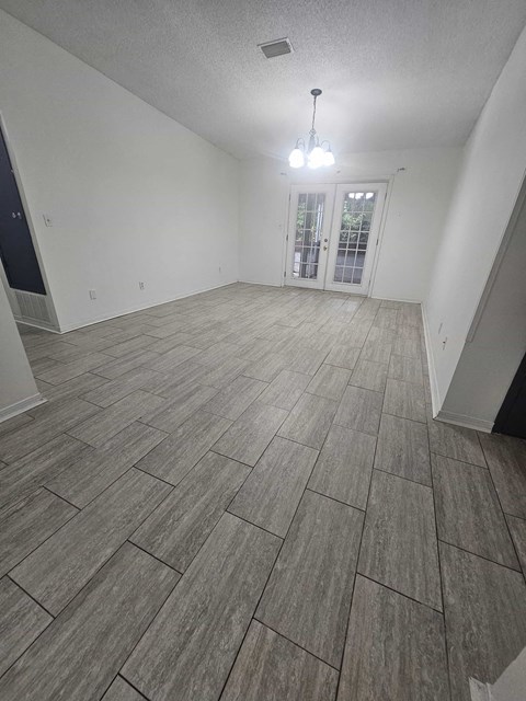the living room and dining room of an empty home with tile flooring