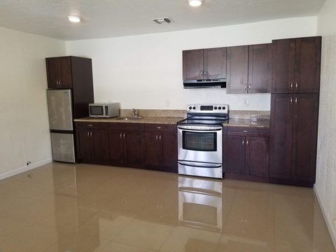 A kitchen with brown cabinets and a stainless steel oven.