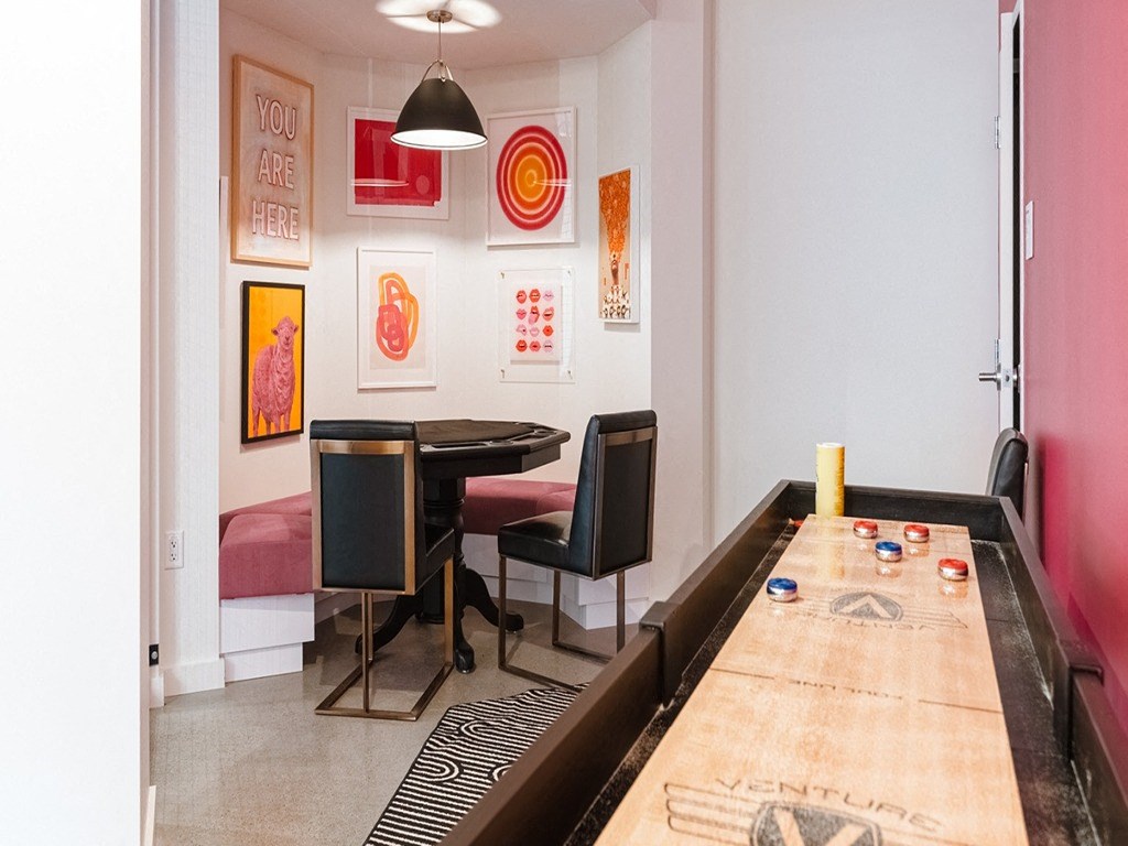 a dining room with a long table and chairs and a wall of art