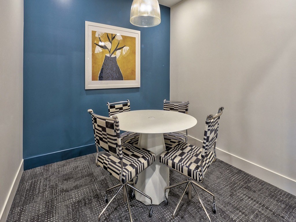 a dining room with a table and chairs and a painting on the wall