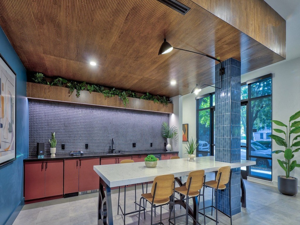 a kitchen with a long table and chairs and a large window