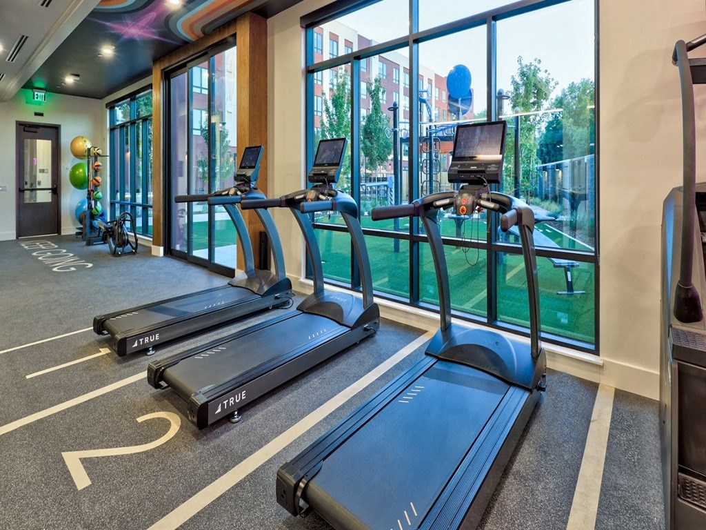 a gym with cardio equipment and a view of a golf course