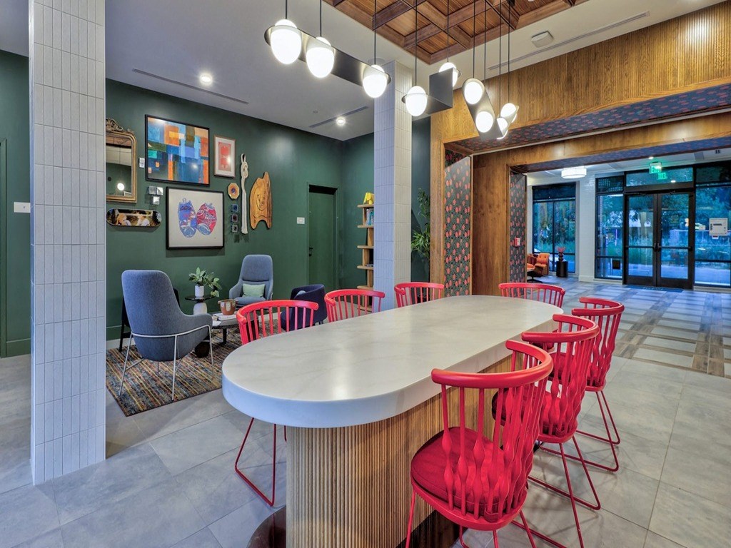 a long table with red chairs in a lobby