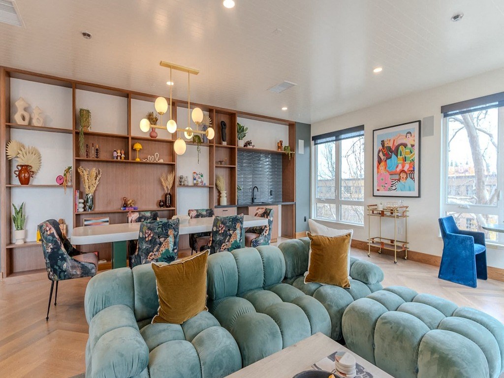 a living room with a blue couch and a table and chairs